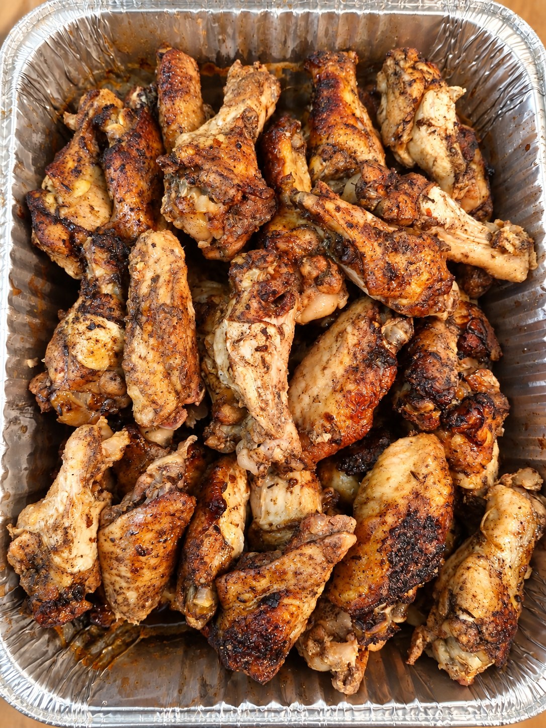 A catering tray of seasoned chicken wings